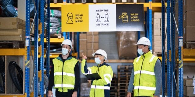 Three workers in a warehouse