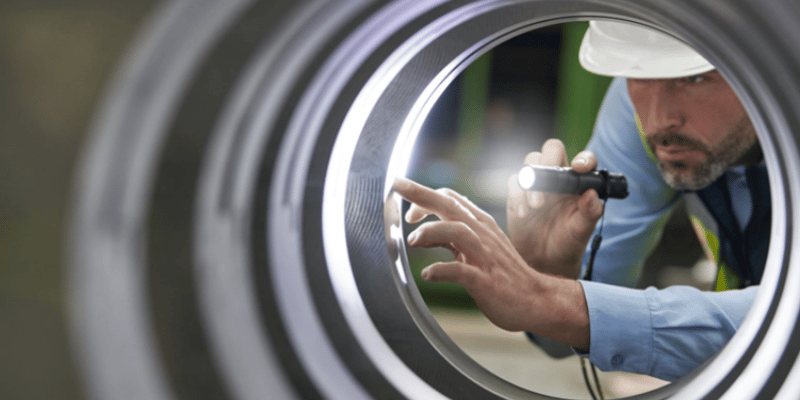 Man inspecting a metal tube