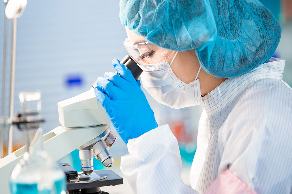 Scientist looking at a sample under a microscope in a laboratory