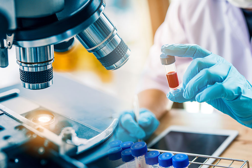 Forensic scientist holding a sample under a microscope